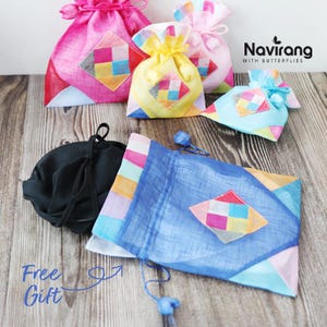 May include: A collection of drawstring pouches in various colors including pink, yellow, light blue, and dark blue, each featuring a central diamond-shaped patch with a multi-colored grid pattern. The text Navirang WITH BUTTERFLIES is visible.