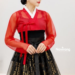 May include: A red sheer long-sleeved hanbok jacket with a white collar and a tie closure, worn over a black top and a black skirt featuring gold-coloured patterns. The text Navirang WITH BUTTERFLIES is visible in the lower right corner of the image.