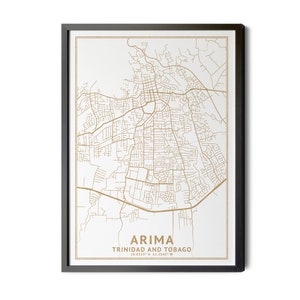May include: A framed map of Arima, Trinidad and Tobago. The map is in gold on a white background, with the city name and coordinates at the bottom. The frame is black, creating a striking contrast.