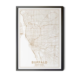 May include: Framed print of a detailed map of Buffalo, New York, in a gold color. The map shows the city's streets and waterways. The print is set against a white background and framed in a black frame. The city name and coordinates are printed at the bottom.