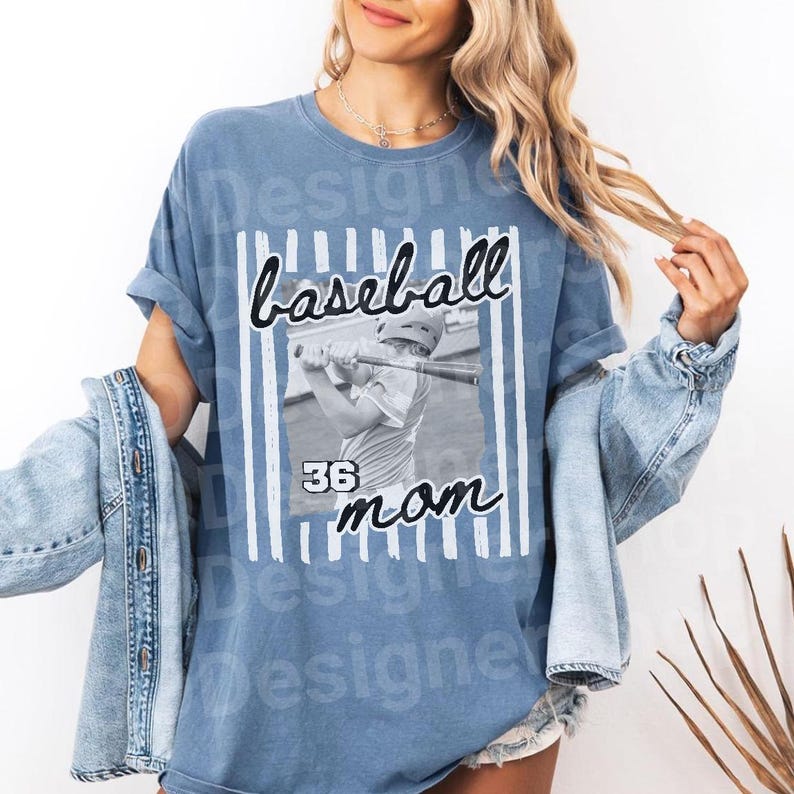 May include: A blue t-shirt with the words "baseball mom" in a script font, with a black and white image of a baseball player. The number "36" is below the image. Vertical white stripes frame the image.