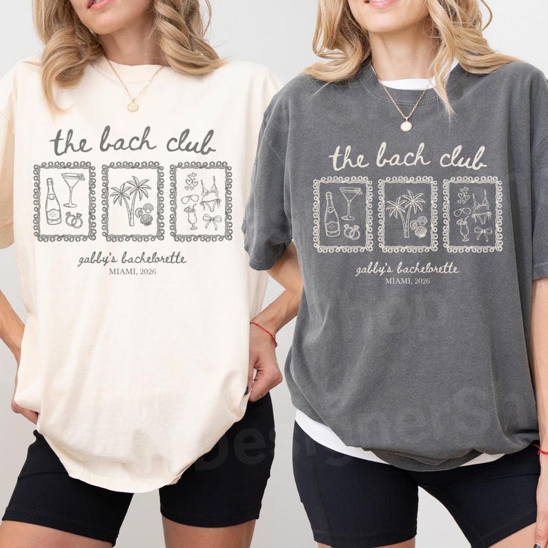 May include: Two t-shirts, one cream and one gray, with the text "the bach club" above three framed illustrations. The illustrations include a champagne bottle, a cocktail, a palm tree, and other party-themed graphics. Below the illustrations is the text "gabby's bachelorette, MIAMI, 2026."