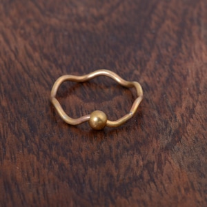 Peut inclure: Une bague en or avec une bande ondulée et une petite perle ronde.