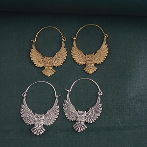 May include: Four hoop earrings with owl designs. Two earrings are gold and two are silver.