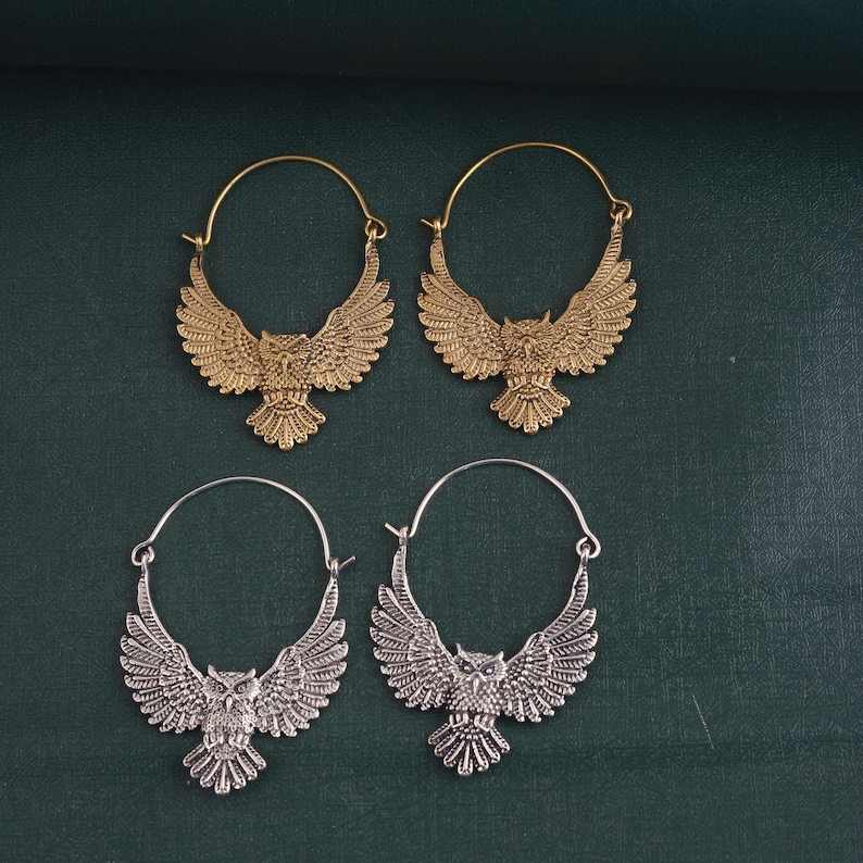 May include: Four hoop earrings with owl designs. Two earrings are gold and two are silver.