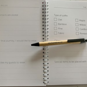 May include: A white notebook with a spiral binding. The notebook has a checklist for planning a funeral. The checklist includes questions about the type of coffin, what the deceased would like to wear, and what items to be placed with them.
