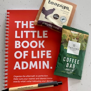 May include: A red spiral bound notebook with the title "The Little Book of Life Admin."  The notebook has a pen and two tea bags on top of it. One tea bag is brown with the text "teapigs. morning glory everyday brew" and the other tea bag is green with the text "TAYLORS of HARROGATE Rich Italian COFFEE BAG -ROAST 4- PROPER COFFEE MADE EASY".