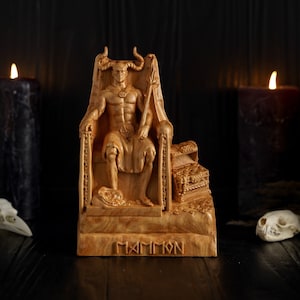 May include: A wooden sculpture of a horned figure sitting on a throne, with the word "MAMMON" carved on the base. The sculpture is surrounded by black candles and skulls.