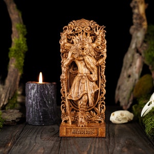 May include: A wooden carving of a demon with multiple arms and a horned head. The carving is on a wooden base with the word "MARBAS" inscribed on it.