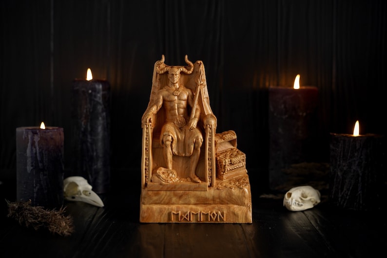May include: A wooden sculpture of a horned figure sitting on a throne, with the word "MAMMON" carved on the base. The sculpture is surrounded by black candles and skulls.