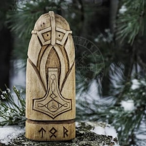 Puede incluir: Una talla de madera del dios n&oacute;rdico Thor, con un casco y sosteniendo su martillo, Mjolnir. La talla est&aacute; inscrita con las runas "T" "O" "R".