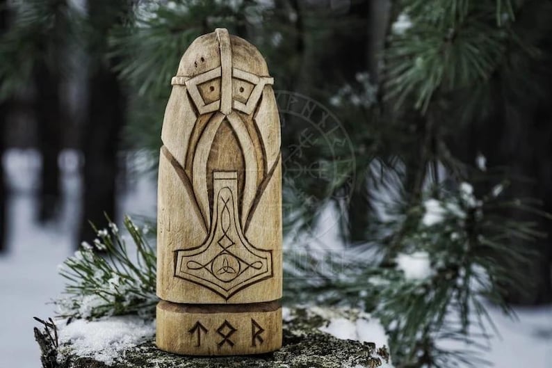 Puede incluir: Una talla de madera del dios n&oacute;rdico Thor, con un casco y sosteniendo su martillo, Mjolnir. La talla est&aacute; inscrita con las runas "T" "O" "R".