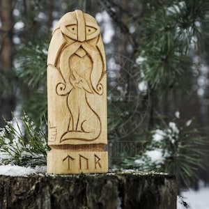 Puede incluir: Una talla de madera del dios n&oacute;rdico Thor, con un lobo a su lado. La talla est&aacute; pintada en tonos de madera natural y tiene la inscripci&oacute;n "TNR" en la parte inferior.