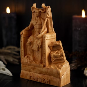 May include: A wooden statue of a demon sitting on a throne. The statue is carved with intricate details and has a dark, menacing expression. The statue is labeled "Mammon" at the base.