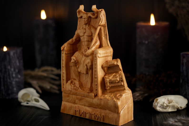 May include: A wooden statue of a demon sitting on a throne. The statue is carved with intricate details and has a dark, menacing expression. The statue is labeled "Mammon" at the base.