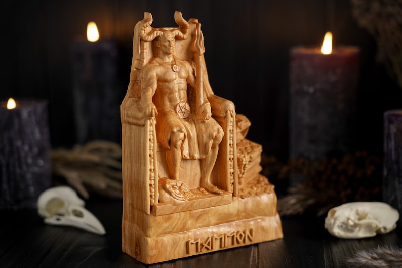 May include: A wooden sculpture of a horned figure sitting on a throne. The figure is wearing a necklace and a belt with a pentagram symbol. The sculpture is labeled "MAMMOTH" at the base.