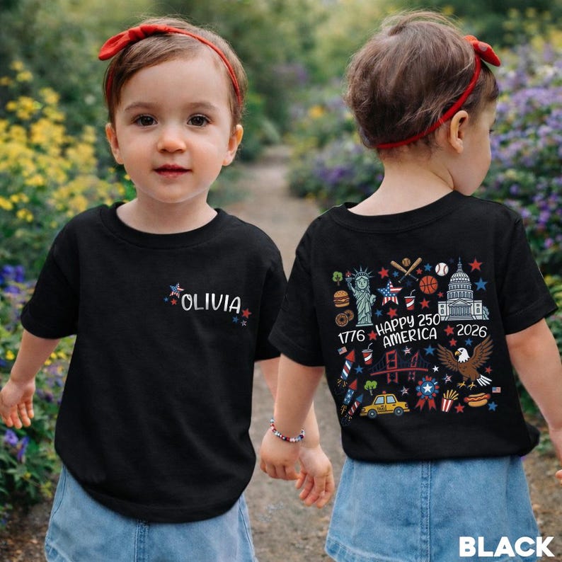 Puede incluir: Camiseta negra con el nombre "OLIVIA" y estrellas en la parte delantera. La parte trasera de la camiseta presenta un gr&aacute;fico colorido con el texto "HAPPY 250 AMERICA 2026" y s&iacute;mbolos patri&oacute;ticos.
