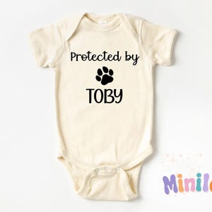 Geschützt durch Hund Baby Onesie®, niedlicher personalisierter Bodysuit, natürlicher benutzerdefinierter Onesie®, Hundegeschwister Outfit, personalisierter Hundename Baby Onesie®