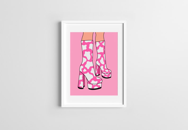 May include: A pair of pink platform boots with a white cow print design. The boots are on a pink background.