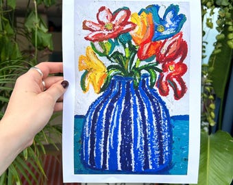 May include: An original painting of colorful flowers in a blue vase with white vertical stripes. The flowers are red, yellow, and blue, with green stems. The artwork is on white paper.