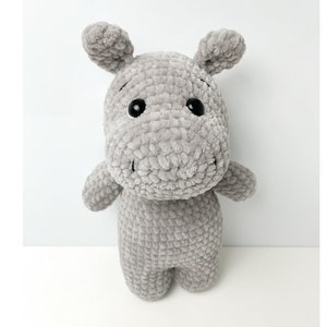 May include: A grey crocheted stuffed hippopotamus toy with black eyes.