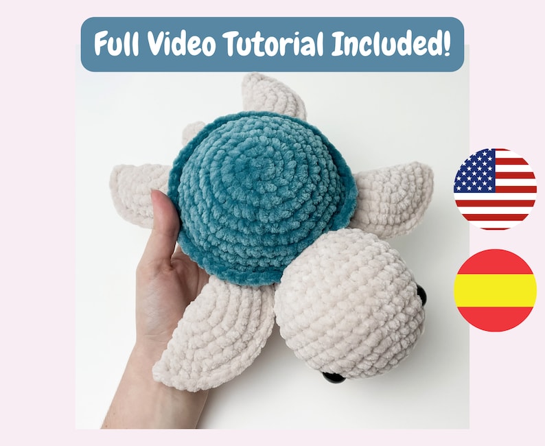 May include: A crocheted plush turtle toy with a teal shell and a beige body. The toy is being held in a hand.