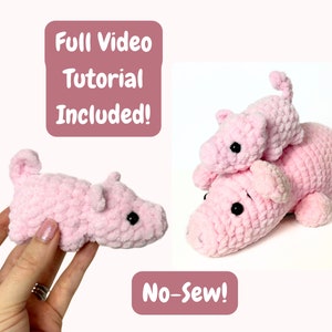 May include: Two pink crocheted pig plushies, one larger than the other, with black eyes. The smaller pig is sitting on top of the larger pig. The text "Full Video Tutorial Included!" and "No-Sew!" is visible in the image.