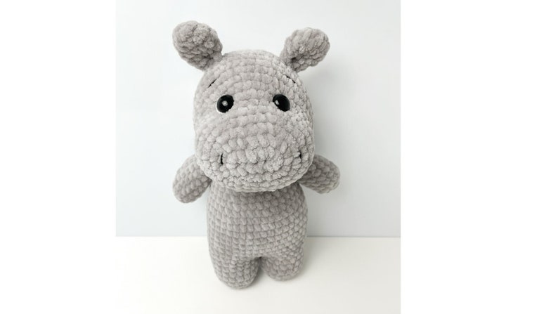 May include: A grey crocheted stuffed hippopotamus toy with black eyes.