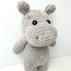 May include: A grey crocheted stuffed hippopotamus toy with black eyes.