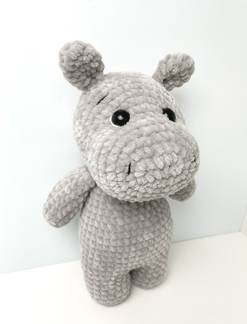 May include: A grey crocheted stuffed hippopotamus toy with black eyes.