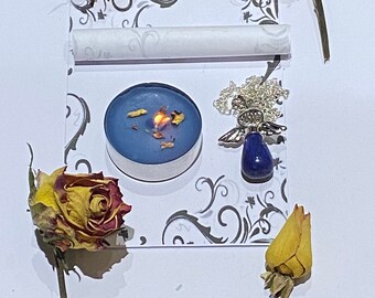 May include: A blue teal candle with dried flowers inside, a silver angel charm with a blue stone, and dried yellow roses on a white background with a gray floral pattern.