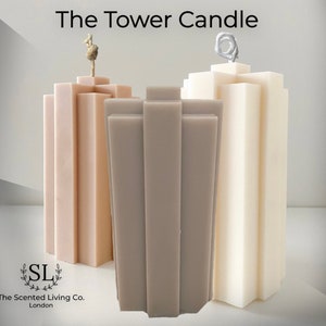 Puede incluir: Tres velas en forma de torre de diferentes colores: beige, gris y blanco. Las velas son altas y rectangulares con un diseño geométrico. Las velas están hechas por The Scented Living Co. London.