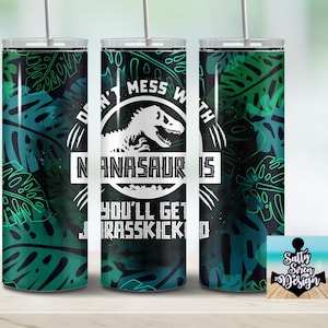 Puede incluir: Un vaso verde y negro con un gr&aacute;fico de dinosaurio blanco y el texto "Don't mess with a  nanasaurs you'll get jurasskicked".