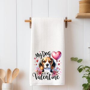 May include: White waffle-weave kitchen towel with a Valentine's Day theme. The towel features a watercolor illustration of a beagle with a pink heart balloon and the text "My Dog is my Valentine."