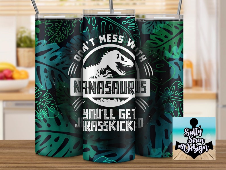 Puede incluir: Un vaso negro y verde con un gr&aacute;fico blanco de un dinosaurio y el texto "Don't mess with Nana-saurus you'll get Jurassic-kicked".