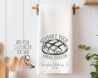 May include: White kitchen towel with black text that reads "Support Your Local Dealer. Jennifer's Baking Co. -EST. 2025-" and a black and white illustration of a loaf of bread.