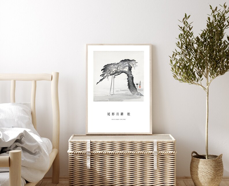 May include: A black and white ink painting of a tree with a swing hanging from its branches. The painting is framed and hanging on a white wall above a wicker chest. The text "北 庐 月 昨" is written in black ink below the painting.