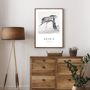 May include: A black and white ink painting of a tree with a single branch reaching out to the right. The tree is set against a light grey background. The painting is framed in a white frame and has the text "北斎 川 粋" in black lettering at the bottom.