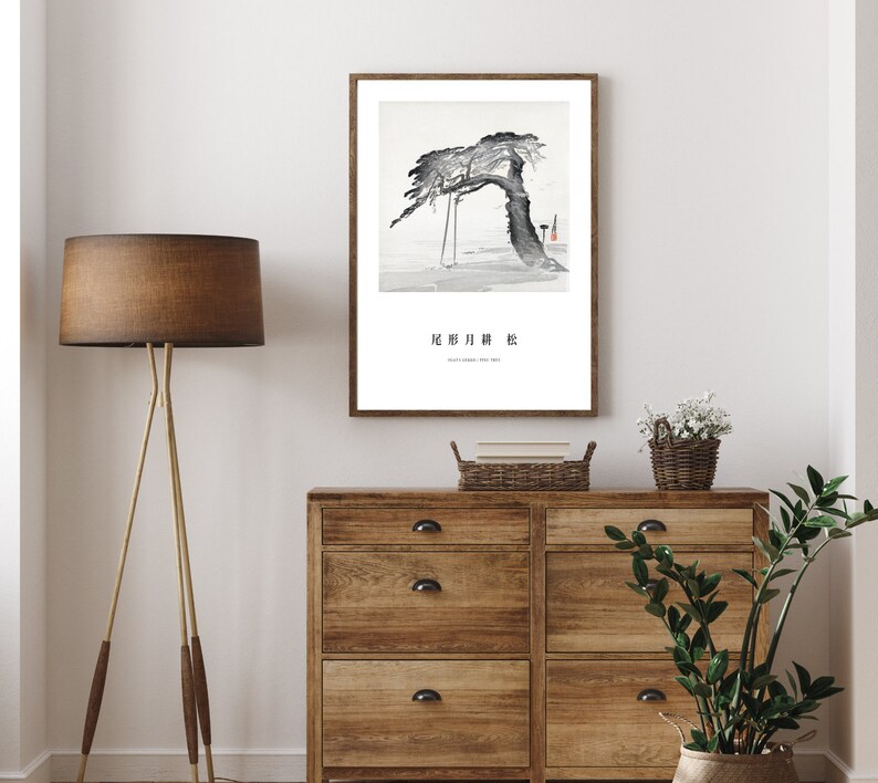 May include: A black and white ink painting of a tree with a single branch reaching out to the right. The tree is set against a light grey background. The painting is framed in a white frame and has the text "北斎 川 粋" in black lettering at the bottom.