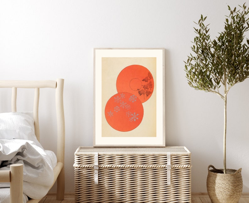 May include: A framed print of a minimalist abstract art piece featuring two overlapping circles in shades of orange with a pattern of small grey flowers inside.