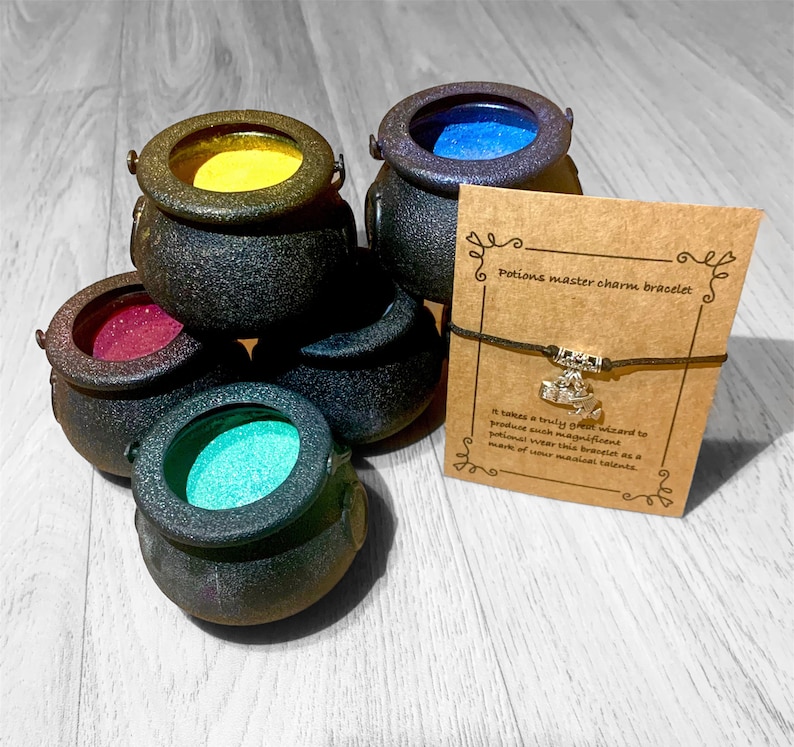May include: A brown charm bracelet with a silver cauldron charm. The bracelet is on a card that reads "Potions master charm bracelet" and "It takes a truly great wizard to produce such magnificent potions. Wear this bracelet as a mark of your magical talents."