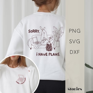 May include: A white sweatshirt featuring a dark brown line art graphic on the back of a person lying on a sofa eating pizza with the text SORRY, I HAVE PLANS. A smaller version of the pizza box graphic is printed on the front left chest area.
