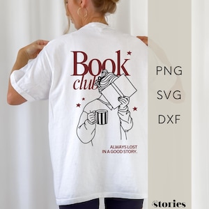 Könnte beinhalten: Ein weißes T-Shirt mit einer dunkelroten und schwarzen Grafik auf der Rückseite. Das Design zeigt eine Person mit einem offenen Buch und einer gestreiften Tasse sowie den Text "Book club" und "ALWAYS LOST IN A GOOD STORY." "PNG SVG DXF" steht daneben.