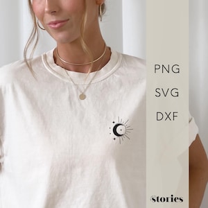 Puede incluir: Una camiseta blanca con un gráfico de luna y sol en blanco y negro con estrellas. El gráfico está en el lado izquierdo de la camiseta. La camiseta la lleva puesta una persona.