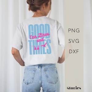 Könnte beinhalten: Ein hellgraues Kurzarm-T-Shirt mit einer großen Grafik auf der Rückseite, die den hellblauen Schriftzug "GOOD TIMES" und den pinkfarbenen kursiven Text "Tan Lines and" sowie eine kleine pinke Bikini-Illustration auf einer Leine zeigt.