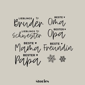 Puede incluir: Una colección de calcomanías de texto negro con palabras en alemán que incluyen Lieblings Bruder, Beste Oma, Lieblings Schwester, Bester Opa, Beste Mama, Beste Freundin y Bester Papa, acompañadas de pequeños corazones y dos copos de nieve.