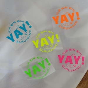 Könnte beinhalten: Vier leuchtend neonfarbene Aufkleber mit dem Text "ICH BIN EIN YAY! SCHULKIND" in einem Kreis. Die Aufkleber befinden sich auf einer weißen Oberfläche.