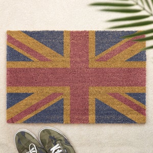 May include: A doormat with the Union Jack flag design. The flag is made of coir and has a red, white, and blue color scheme.