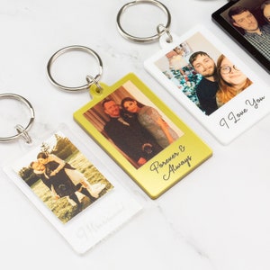 May include: Three photo keychains with different couples and personalized messages. The keychains are made of clear acrylic with a gold or white border. The messages on the keychains are "Forever & Always", "I Love You", and "Married".