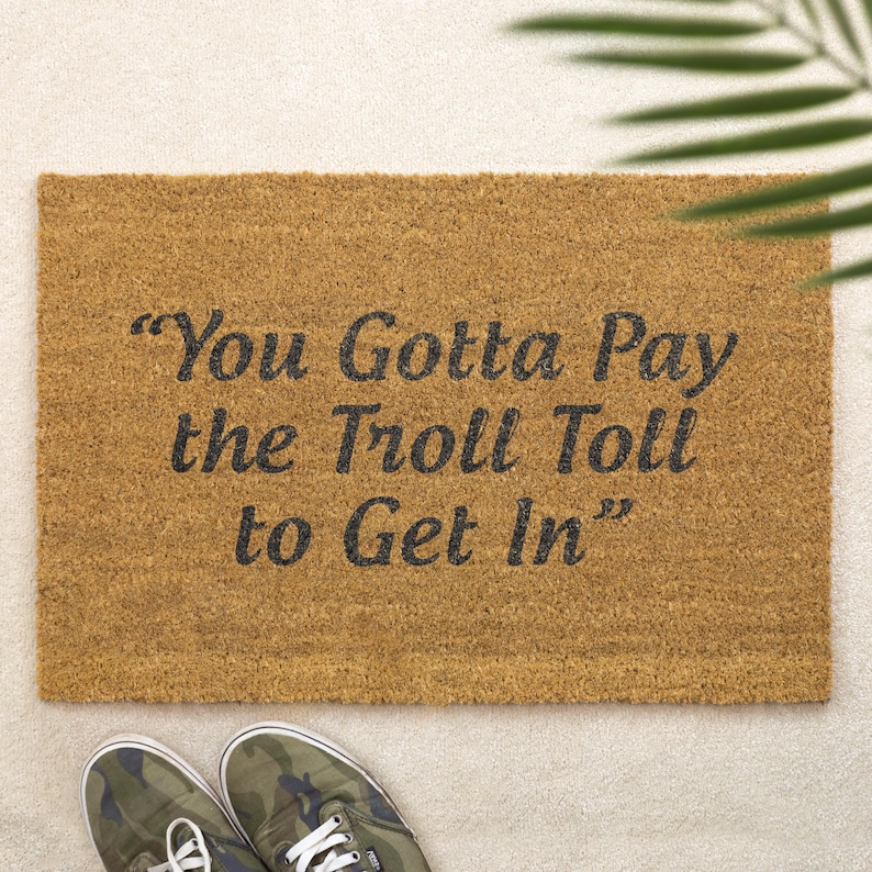 May include: A brown coir doormat with the text "You Gotta Pay the Troll Toll to Get In" in black lettering.